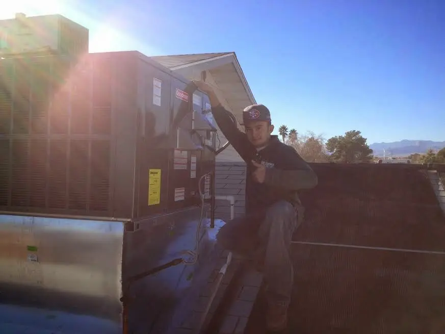 HVAC technician performing AC Tune-Up on a rooftop unit in Fruitvale